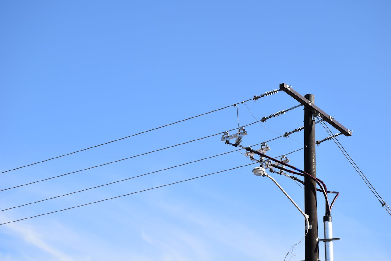 Low angle view of power lines and pole against a blue sky in Logan, Utah.